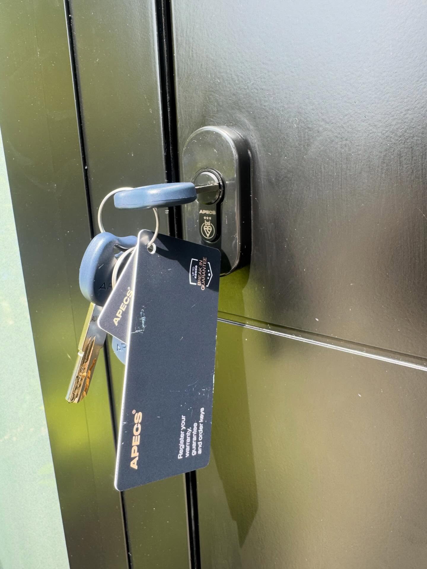 Black 3 star lock with Keys and key card attached to a door handle on a metallic door.