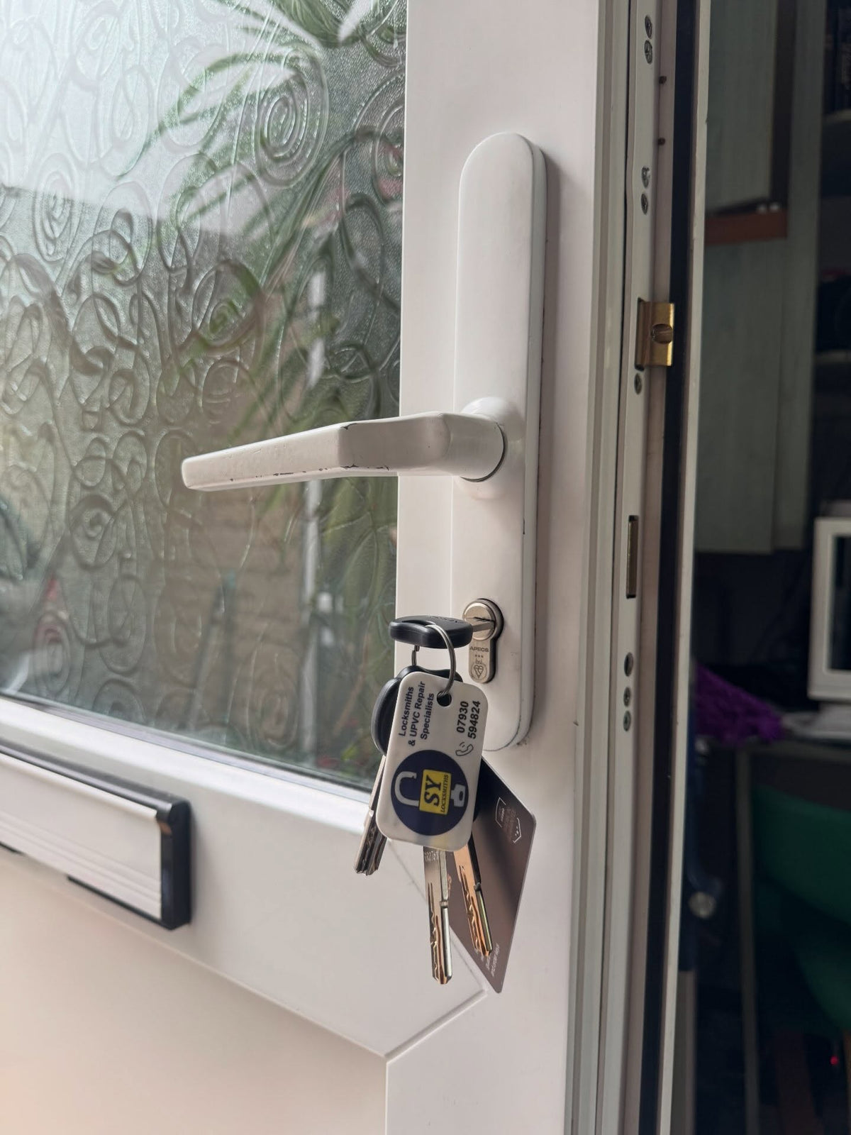 British standard euro lock fitted to a white upvc door with SY Locksmiths key tag attached