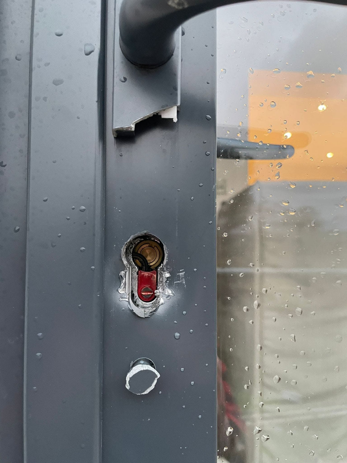 grey door with damage to the door, lock and handles after a burglary in Sheffield