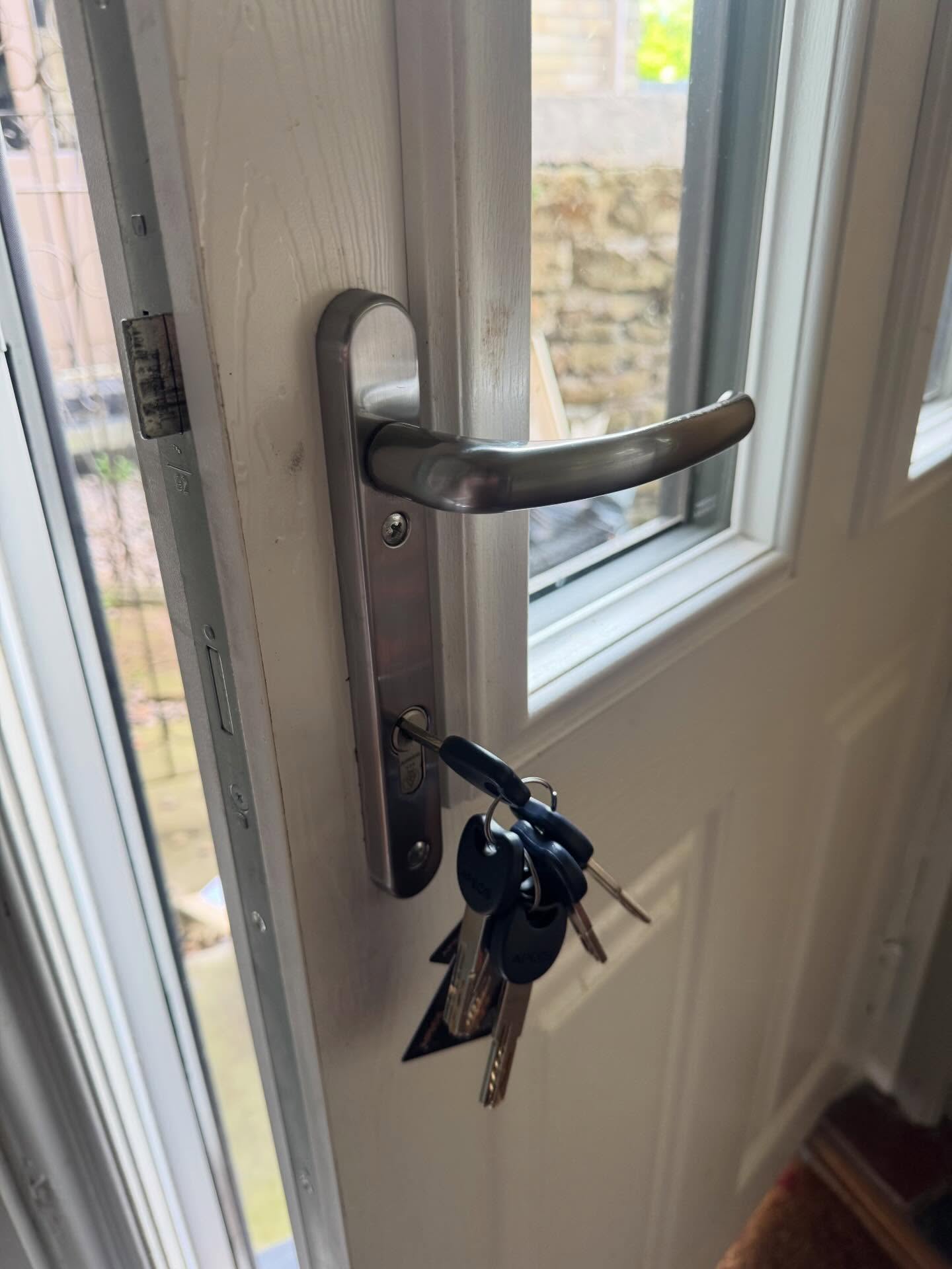 Door handle with keys on a white composite door after carrying out realignment in Darnall 