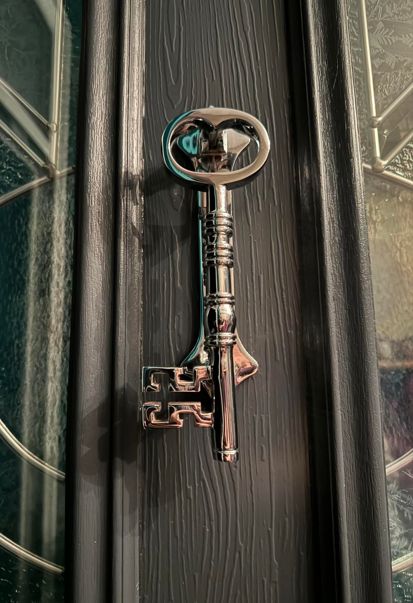 Decorative key on a dark wooden surface with glass panels