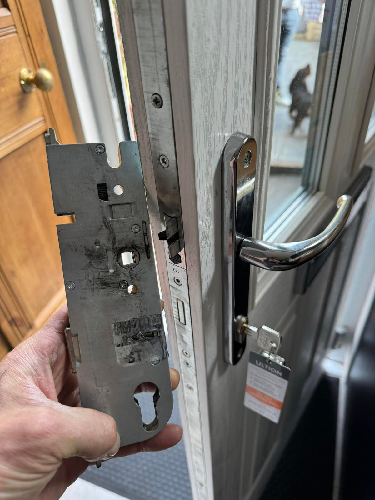 Faulty FUHR multi point lock gearbox held up in front of white door. 