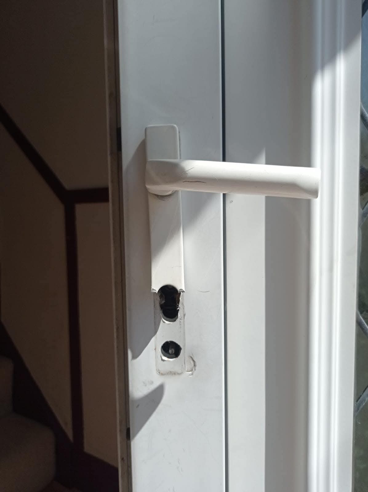 Close-up of a white snapped door handle  on a glass door after a break in