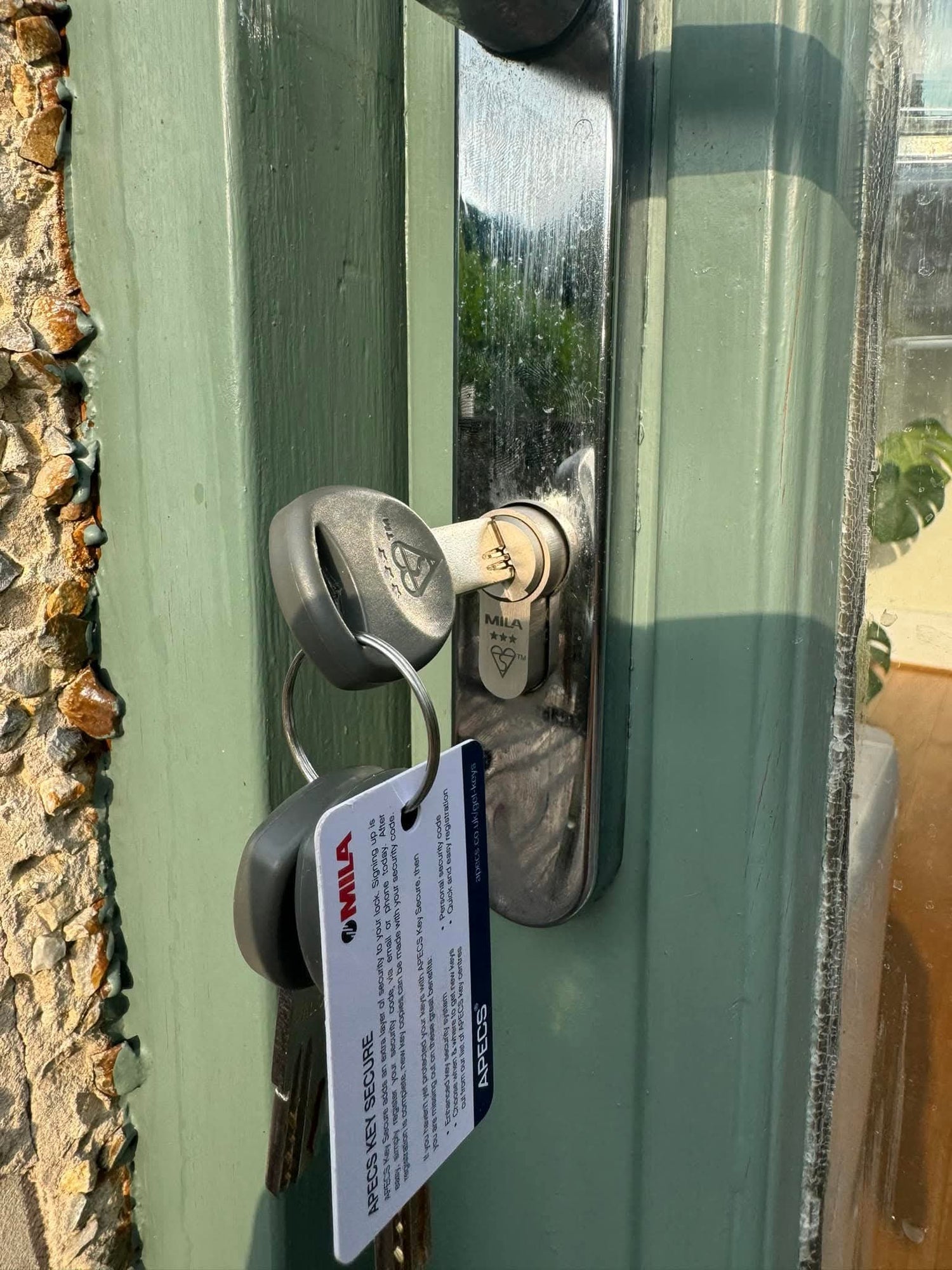 Mila British Standard anti snap lock fitted to a green door with chrome door handle
