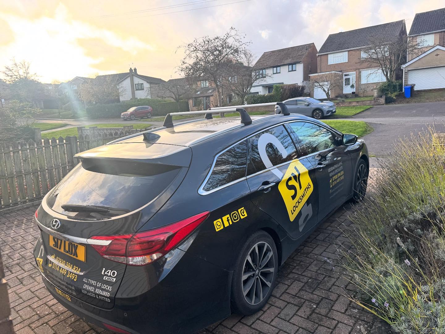 SY Locksmiths vehicle parked on customers drive in Hillsborough displaying signage including company logo and yellow text