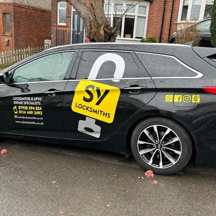 Black car with SY Locksmiths branding on a residential street