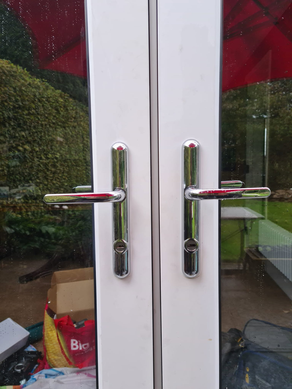 Two white French style patio doors with security upgraded to 2 star secured by design chrome door handles with cylinder guards