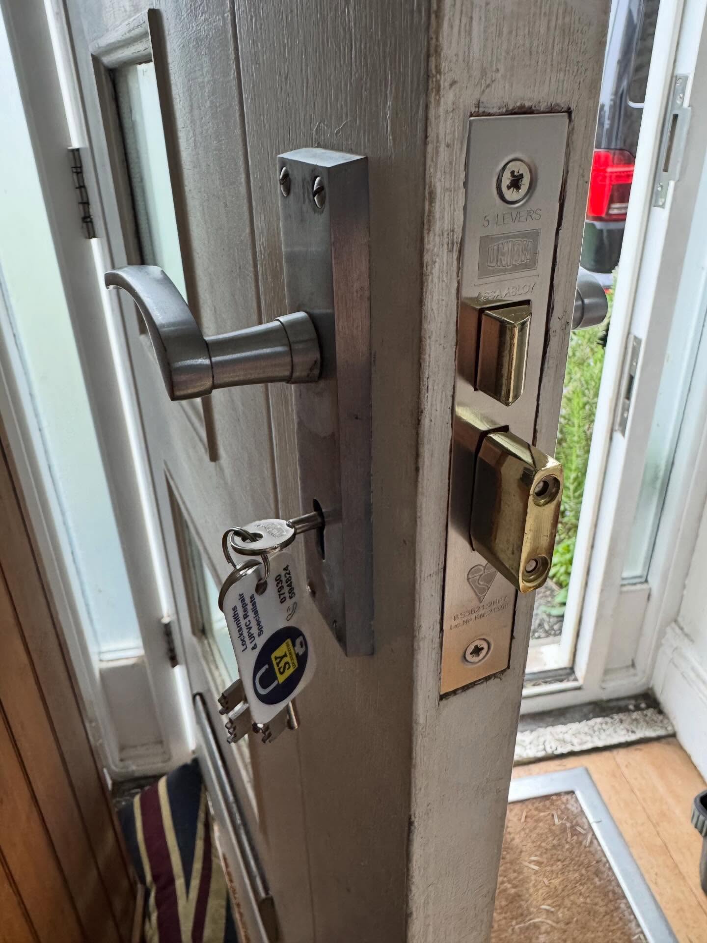 Close-up of a door handle and BS3621 Sash lock lock on a wooden door fitted in Dore.